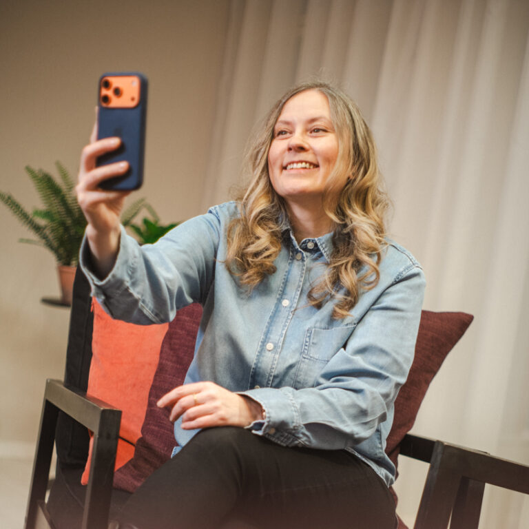 Maria Erikslund Kind Companyn sisältösuunnitelija kuvaamassa videota puhelimella.